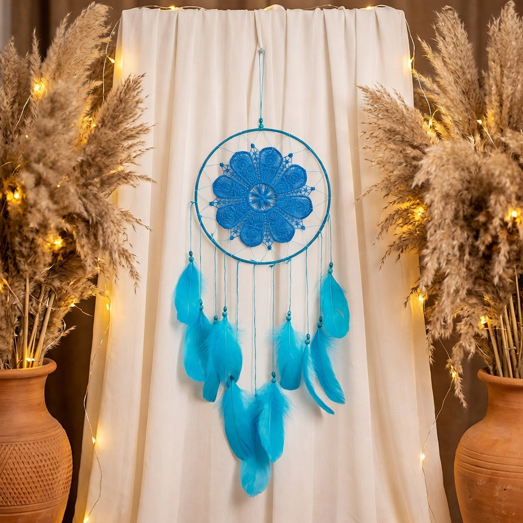Blue dreamcatcher hanging against a white curtain with decorative plants and lights.