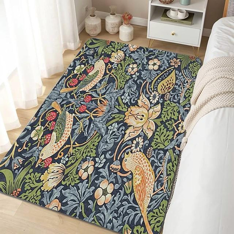Navy blue William Morris Strawberry Thief area rug with bird and floral motifs in a bedroom with sheer curtains