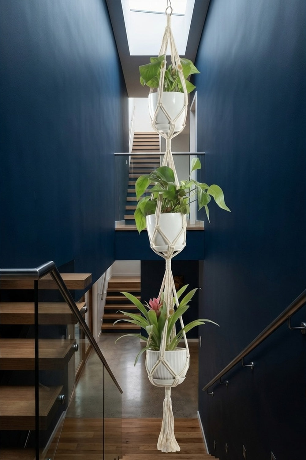Triple cascade macrame plant hanger with three pots on navy staircase wall, tall plant decor