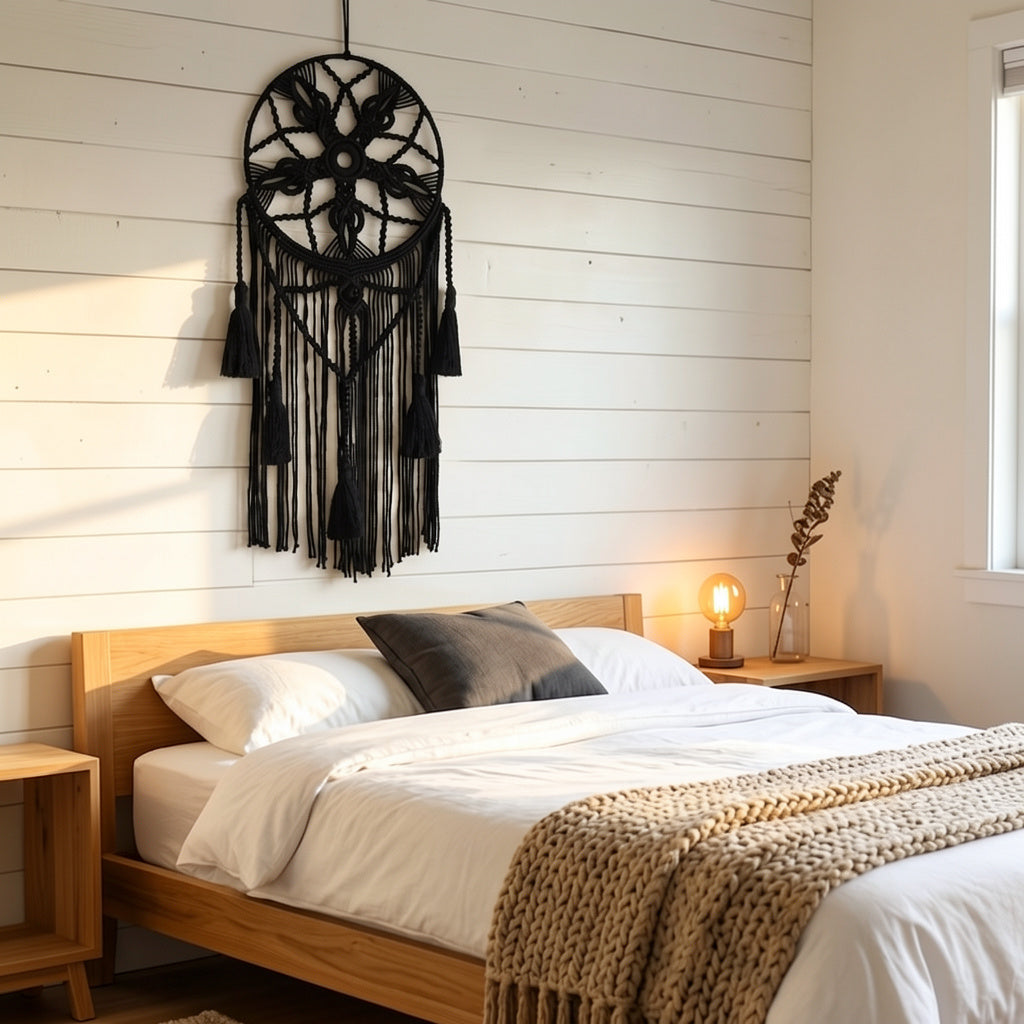 Large black macrame dreamcatcher with tassel fringe on white shiplap wall above wooden bed modern boho bedroom — Bohoartis