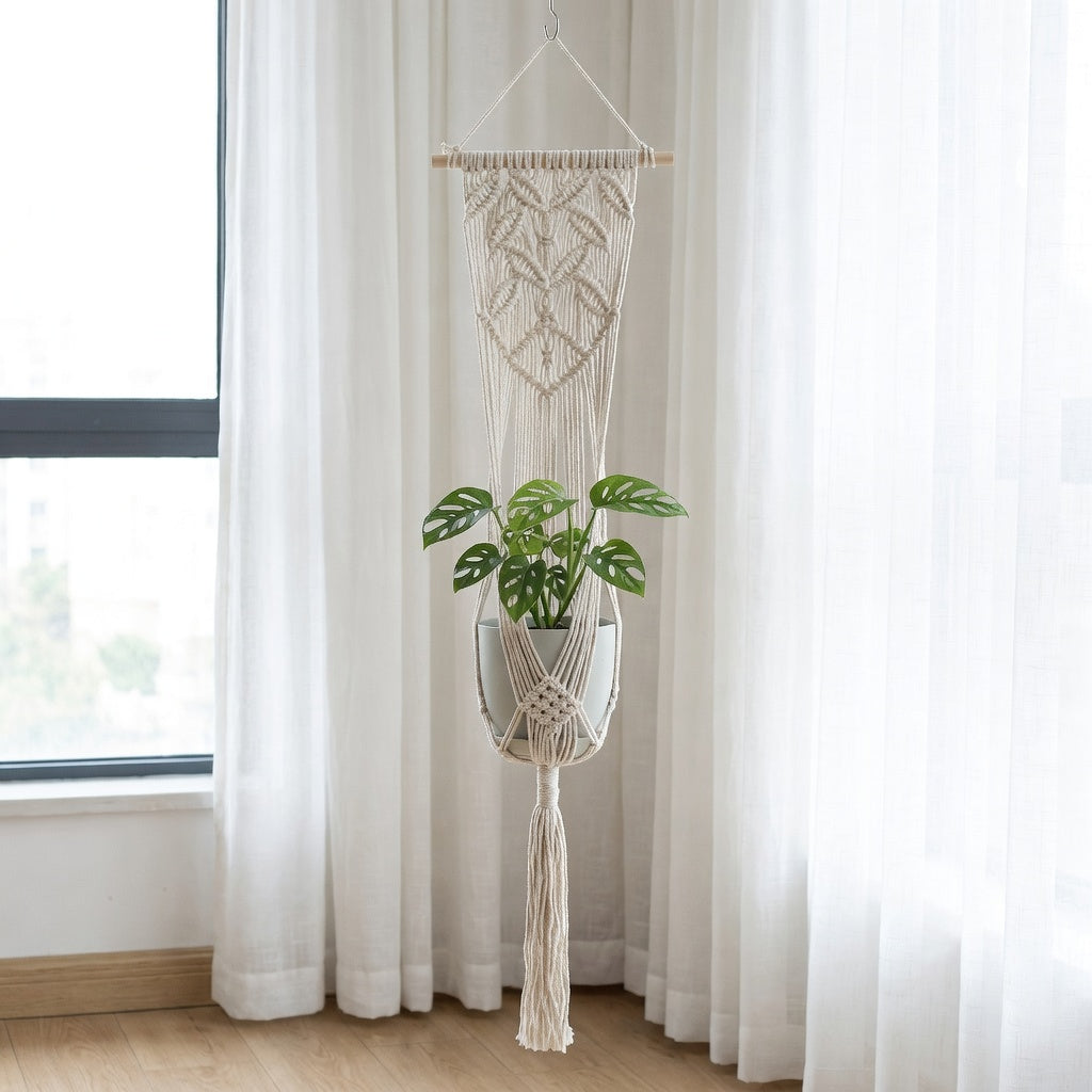 Beige cotton rope plant hanger with wooden dowel hanging near window in Scandinavian bedroom natural light