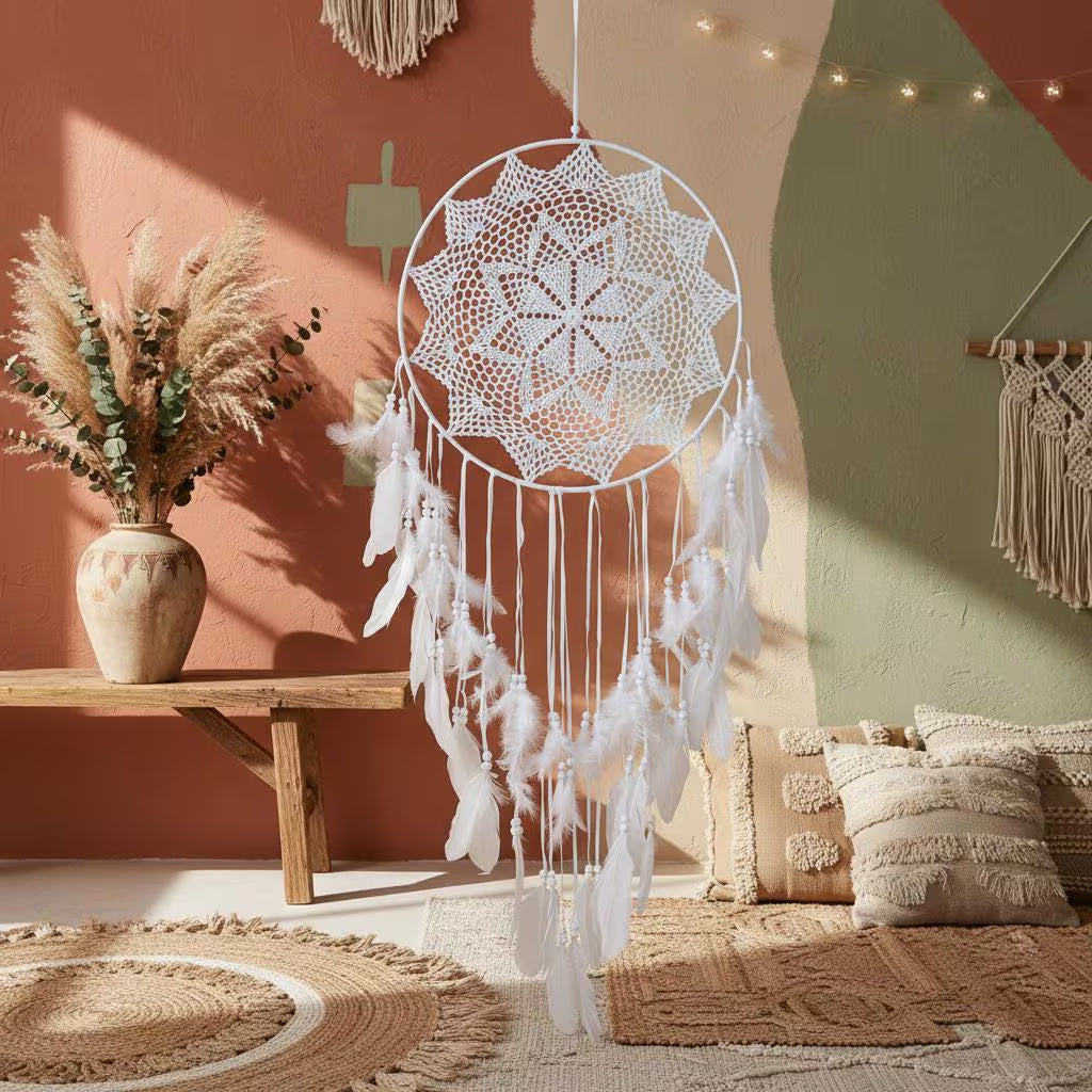 White dreamcatcher hanging in a cozy room with a wooden bench, vase, and pillows.