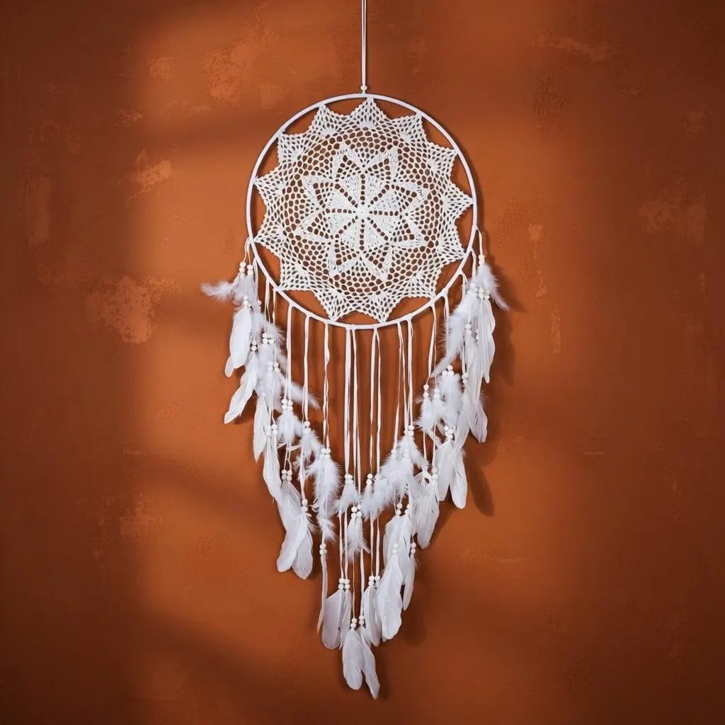 White dreamcatcher with feathers against an orange wall