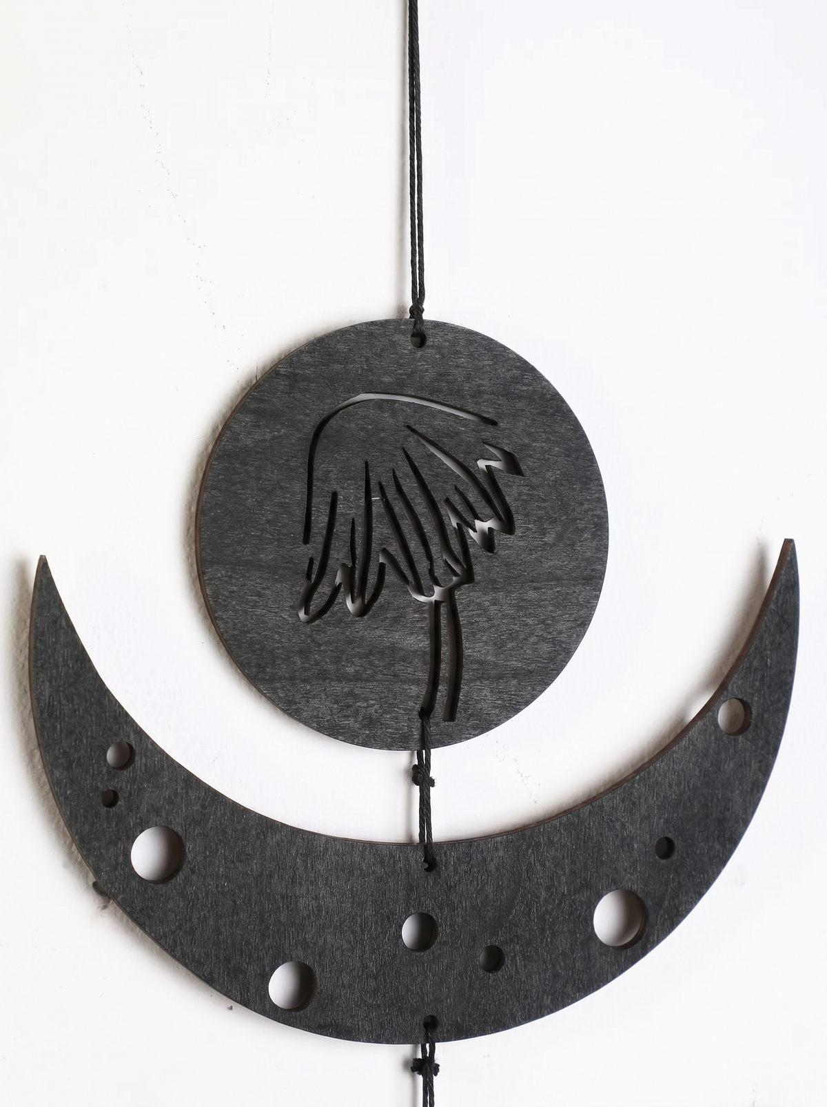 Gothic boho wall hanging — black wooden moon phases with botanical motifs in Japandi home