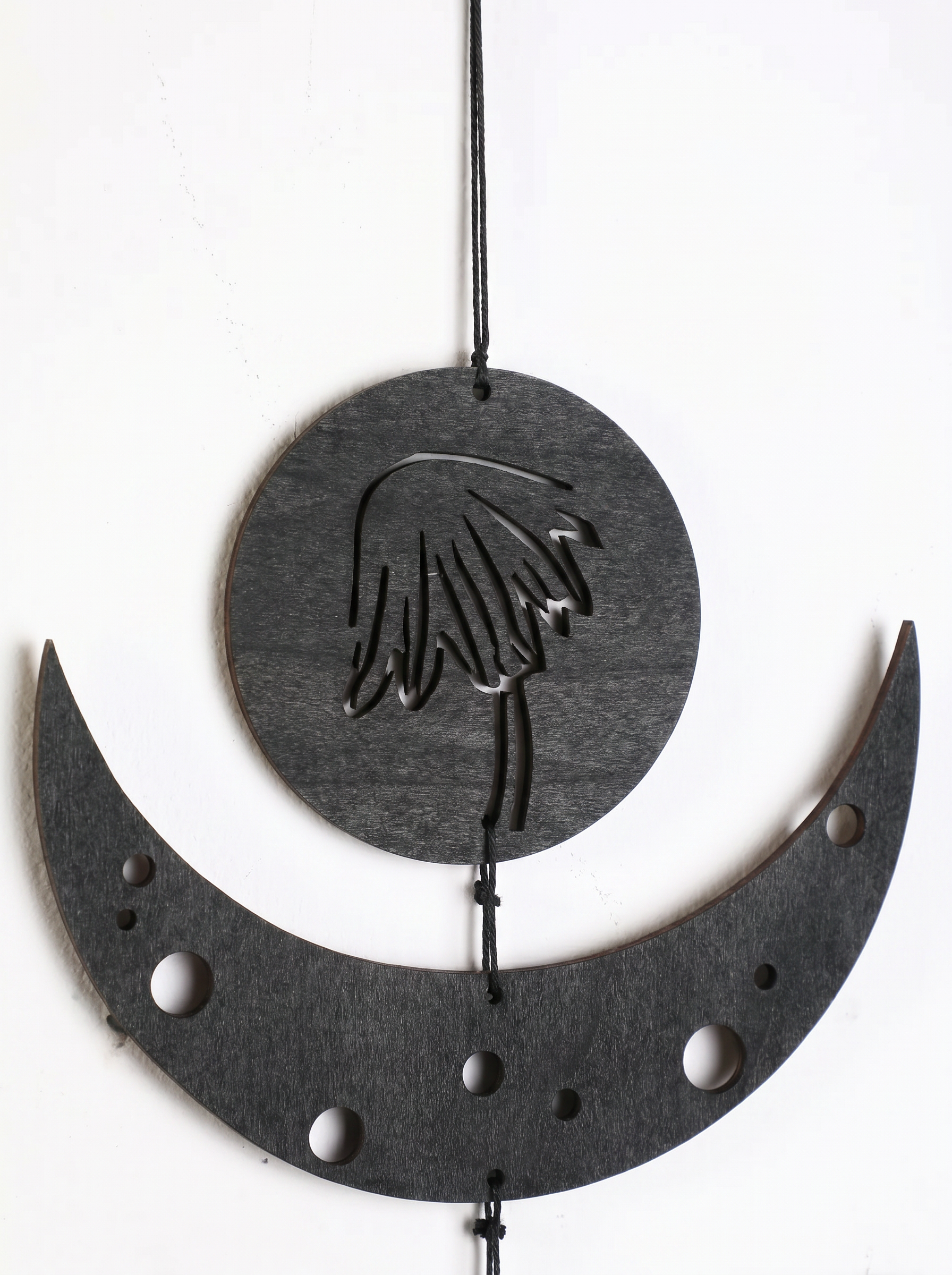Gothic boho wall hanging — black wooden moon phases with botanical motifs in Japandi home