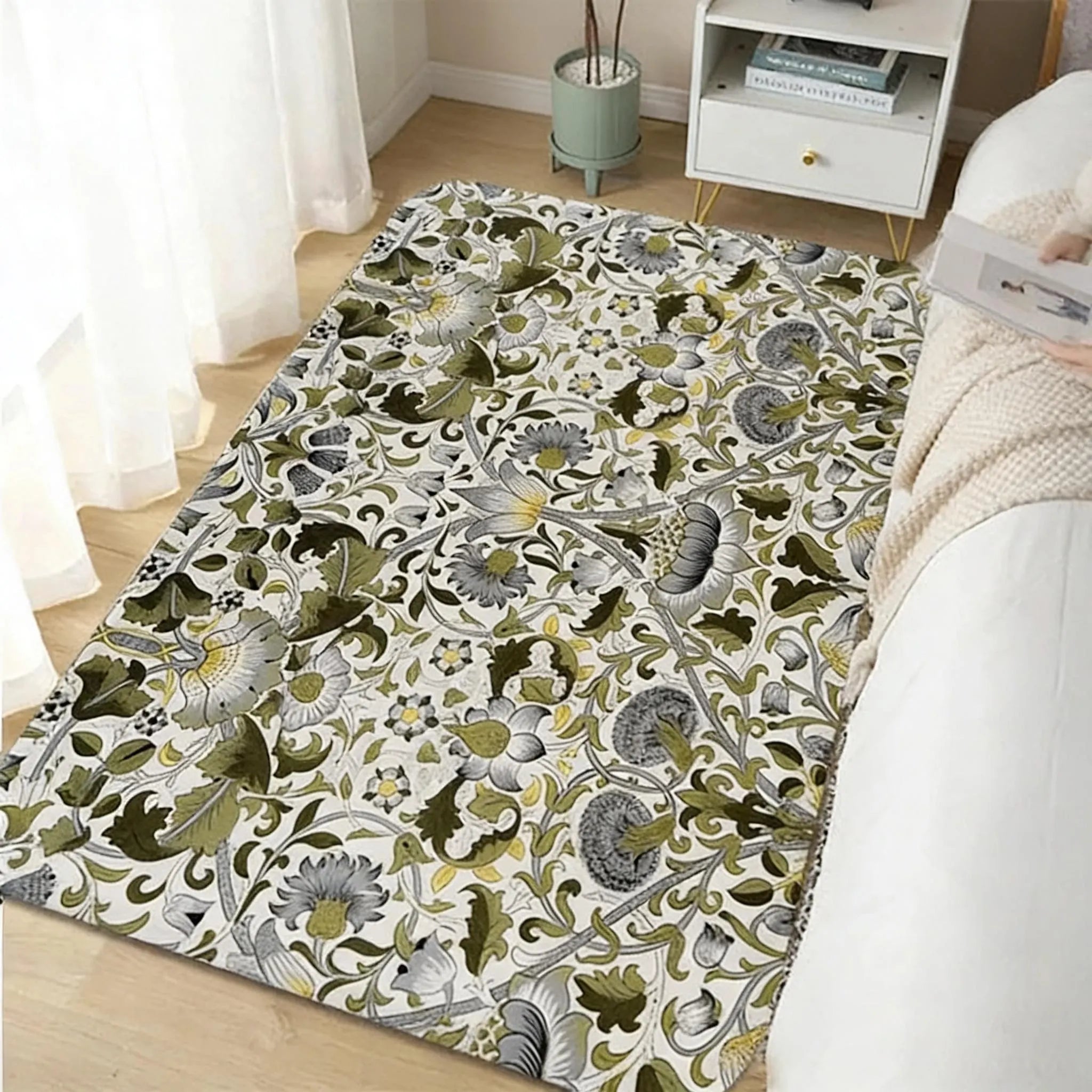 Olive green William Morris floral area rug in a bedroom near a sunlit window