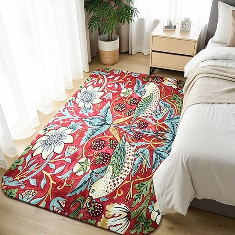 Red and coral William Morris floral area rug in a bedroom setting next to a white dresser and potted plant