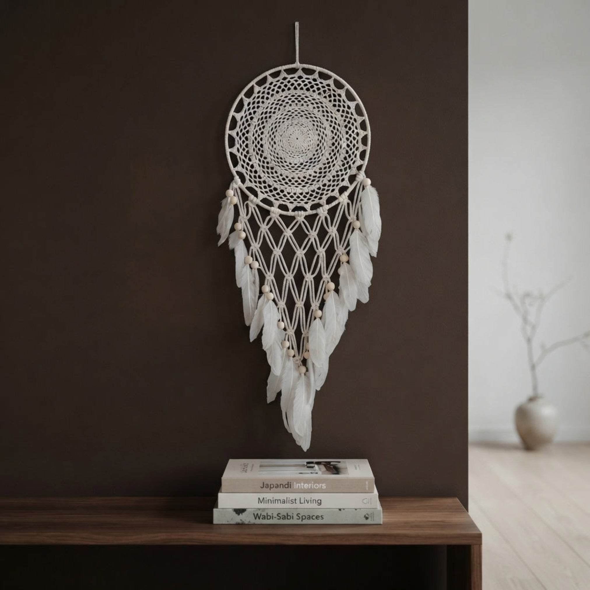 Cream crochet dreamcatcher with wood beads displayed above a console table on a brown accent wall