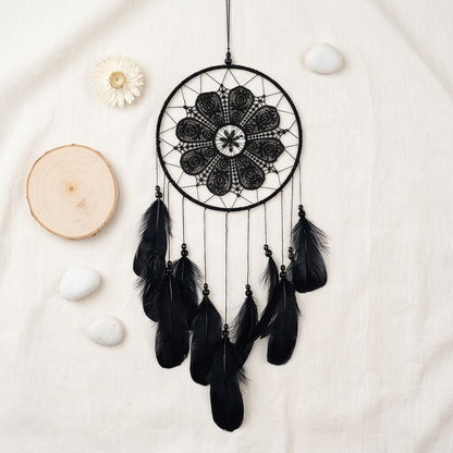 Black lace dream catcher with dark feathers flat lay on cream linen — product detail photo