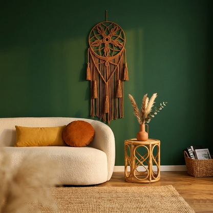 Brown macrame dreamcatcher with cotton tassels on forest green wall above cream sofa boho living room — Bohoartis