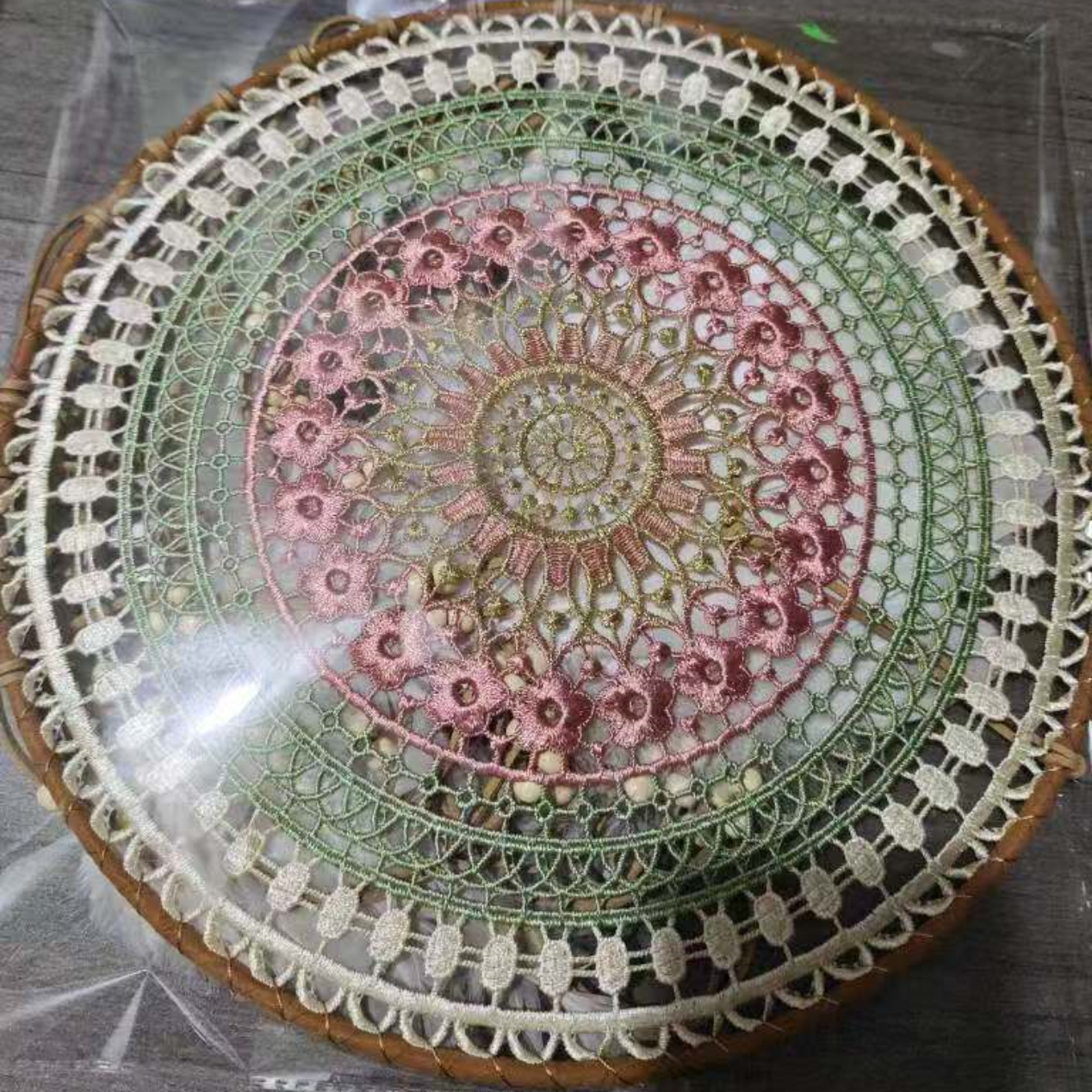 Round embroidered dreamcather with floral patterns on a clear surface