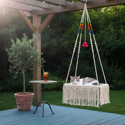Macrame hanging cat bed on a boho patio with a potted plant nearby — Bohoartis