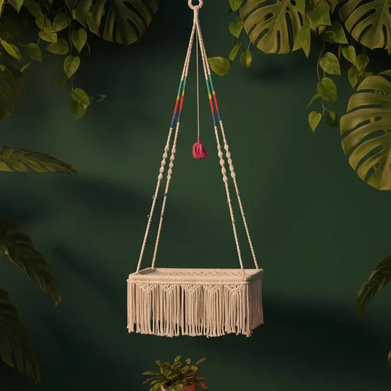 Macrame cat hammock with wooden beads displayed against lush green foliage