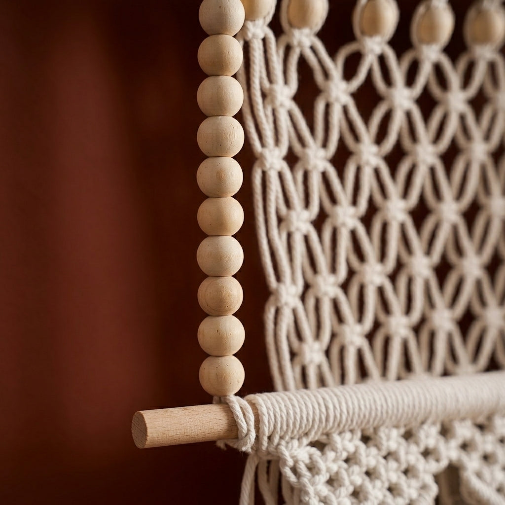Close-up of wooden beads threaded beside the diamond net of a macrame hanging shelf on a natural wood dowel