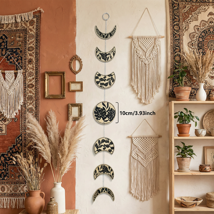 Moon phase wall hanging near dried pampas grass and window in earthy boho living room