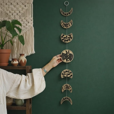 Moon phase wall hanging boho garland with black botanical pattern, 7 lunar cycle discs, celestial wall decor
