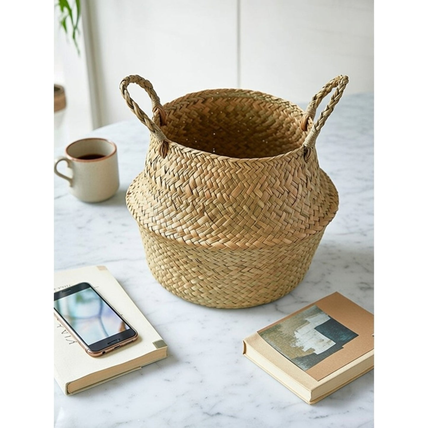 Handwoven seagrass belly basket on marble table coastal boho storage organizer